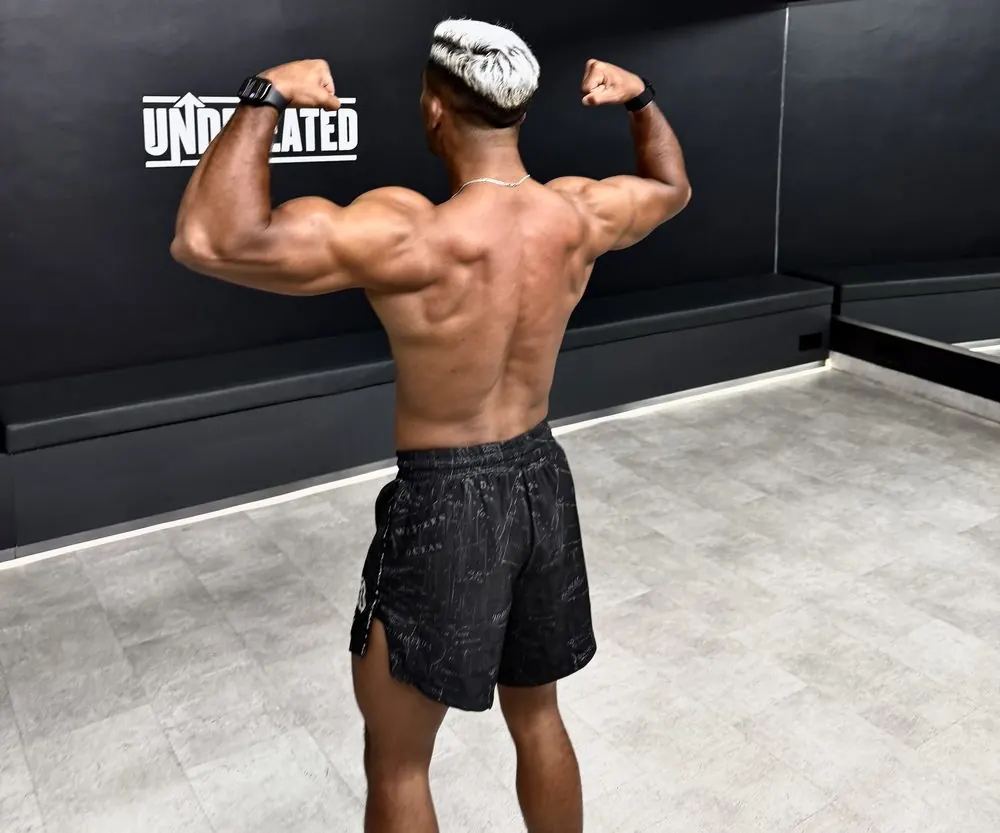 Coach flexing back muscles